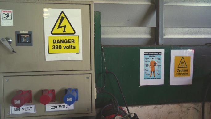 工业电气维护。有警告标志的施工区域高压接线盒。