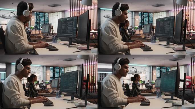 印度男性游戏程序员在游戏设计工作室的桌面电脑上编程。专注的人写行代码，为新的沉浸式3D生存视频游戏做