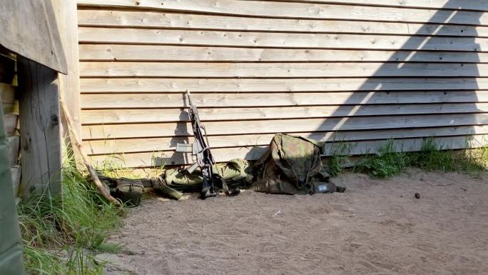 近景士兵无人看管的G-36枪在他的军用包和背心休息，在外面的建筑墙