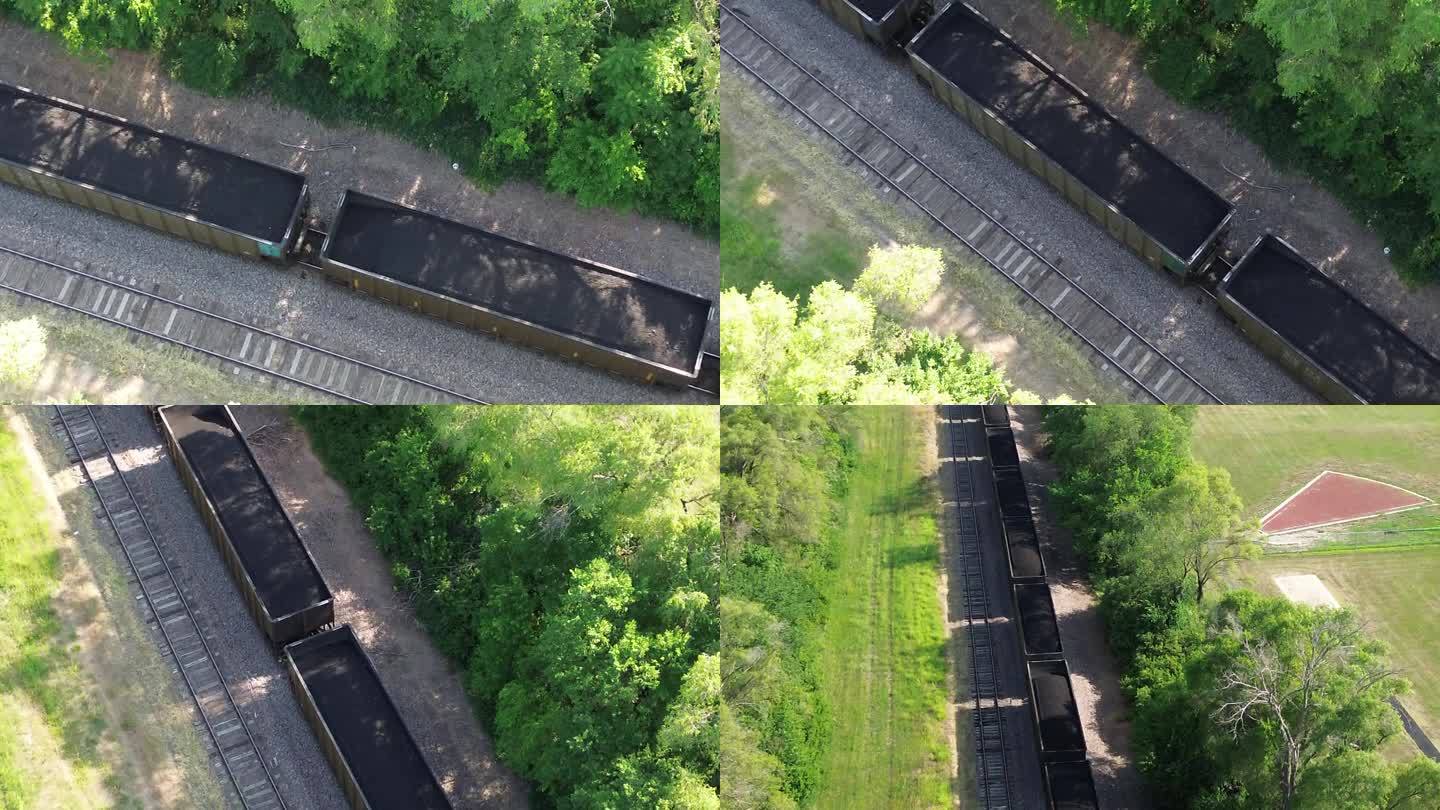鸟瞰图:一列工业火车载着黑色的石头穿过田野