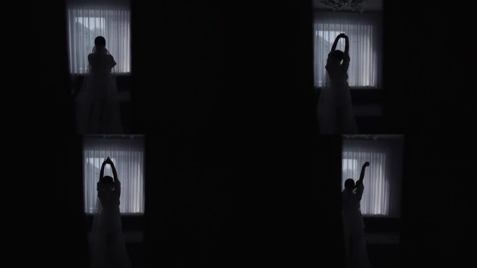 一个美丽性感新娘的剪影透过窗户摆姿势。慢动作