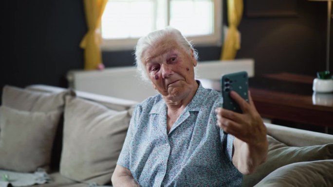 80年代的老奶奶在家里用手机自拍，玩得很开心