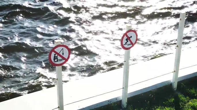 码头上的禁止标志禁止垂钓和潜水游泳。拍打波水