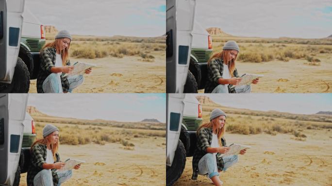 一名妇女在沙漠某处的一辆露营车前看地图