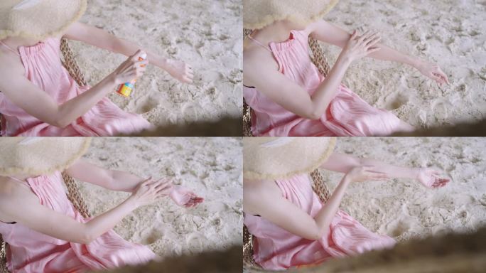 一名女子躺在海滩的吊床上使用防晒霜