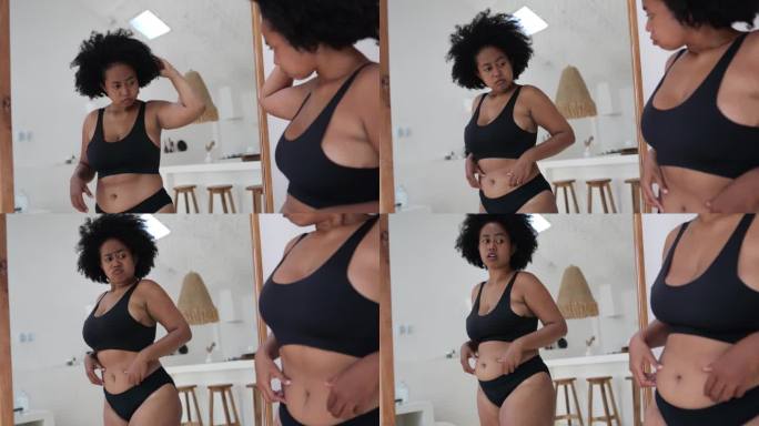 镜子前的黑人妇女对自己超重、肥胖、不健康的身体感到沮丧。自卑，对自己的身体持批判态度，内心对肥胖感到