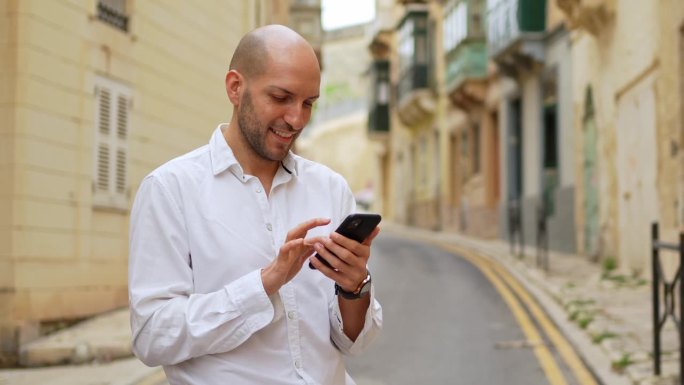 在马耳他的Cospicua，年轻的男游客正在用智能手机查找路线