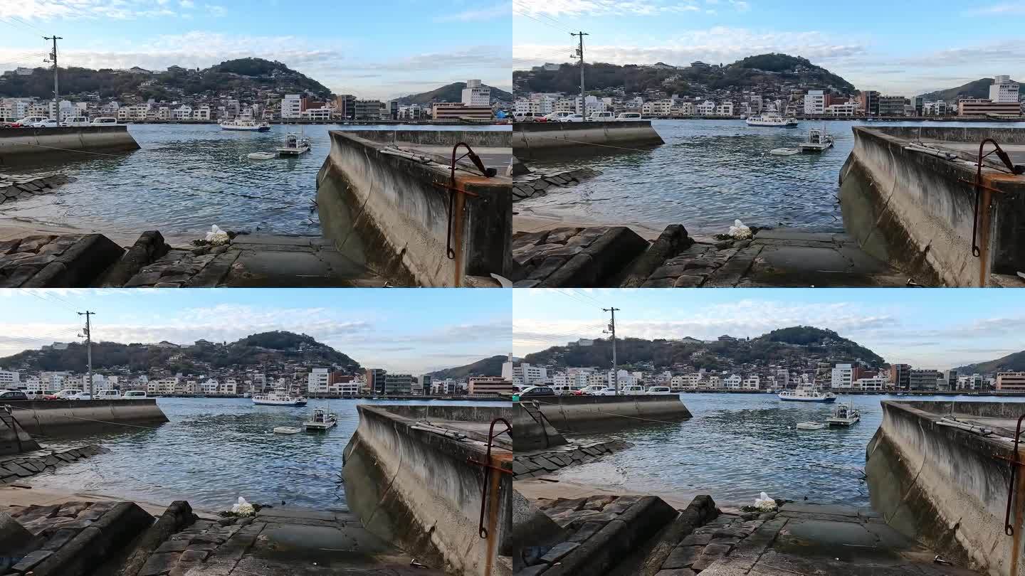 广岛县尾道港。有波浪和渡船的港池。山坡上的城市。日本
