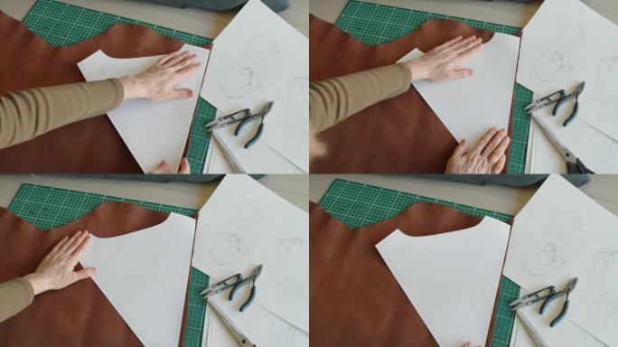 一个无法辨认的女人的手在一块皮革上放置图案