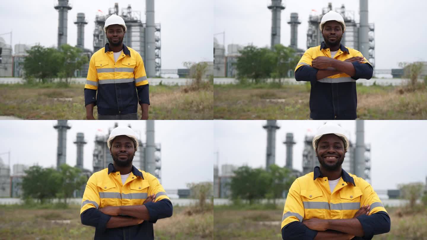 当一名工程师站在电厂工厂前的户外时，这一刻充满了骄傲和自信。这位工程师双臂交叉，面带温暖的微笑，穿着
