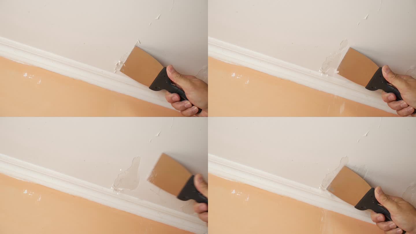 用抹刀把天花板上残留的旧油漆刮掉。施工工程。