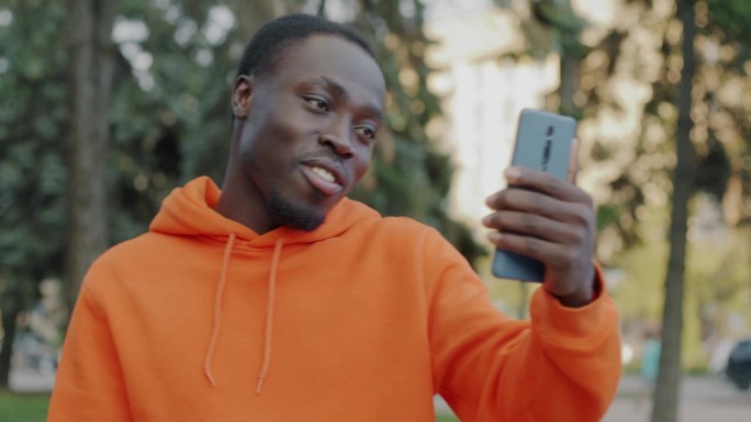 快乐的非裔美国学生在城市户外进行在线视频通话聊天和挥手的肖像