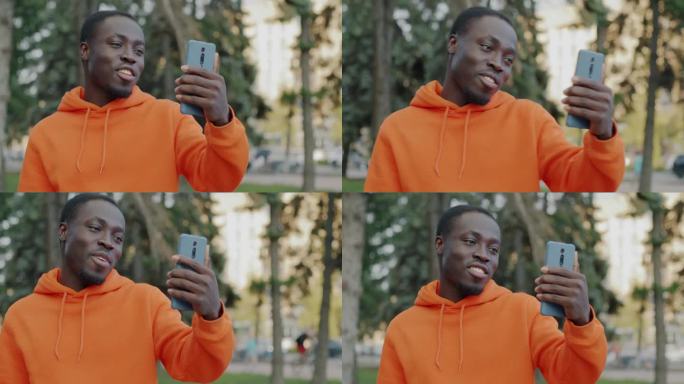 快乐的非裔美国学生在城市户外进行在线视频通话聊天和挥手的肖像