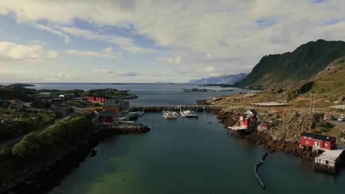 无人机飞过挪威渔村的船坞和通往广阔水面的公路桥