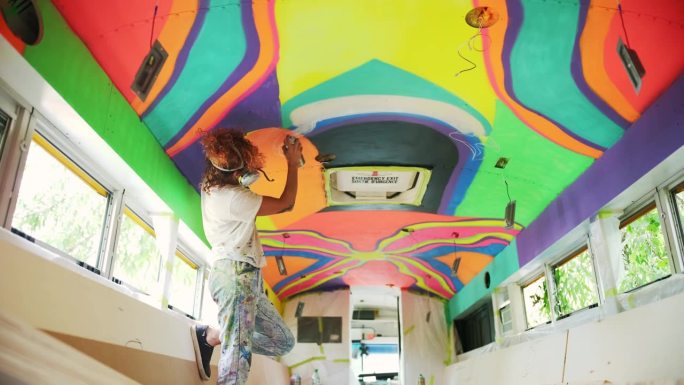 中年成年伊朗女艺术家在派对巴士上画壁画