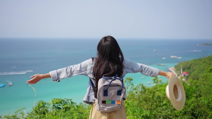 4K亚洲女人在热带岛屿上度假，看着美丽的海洋。