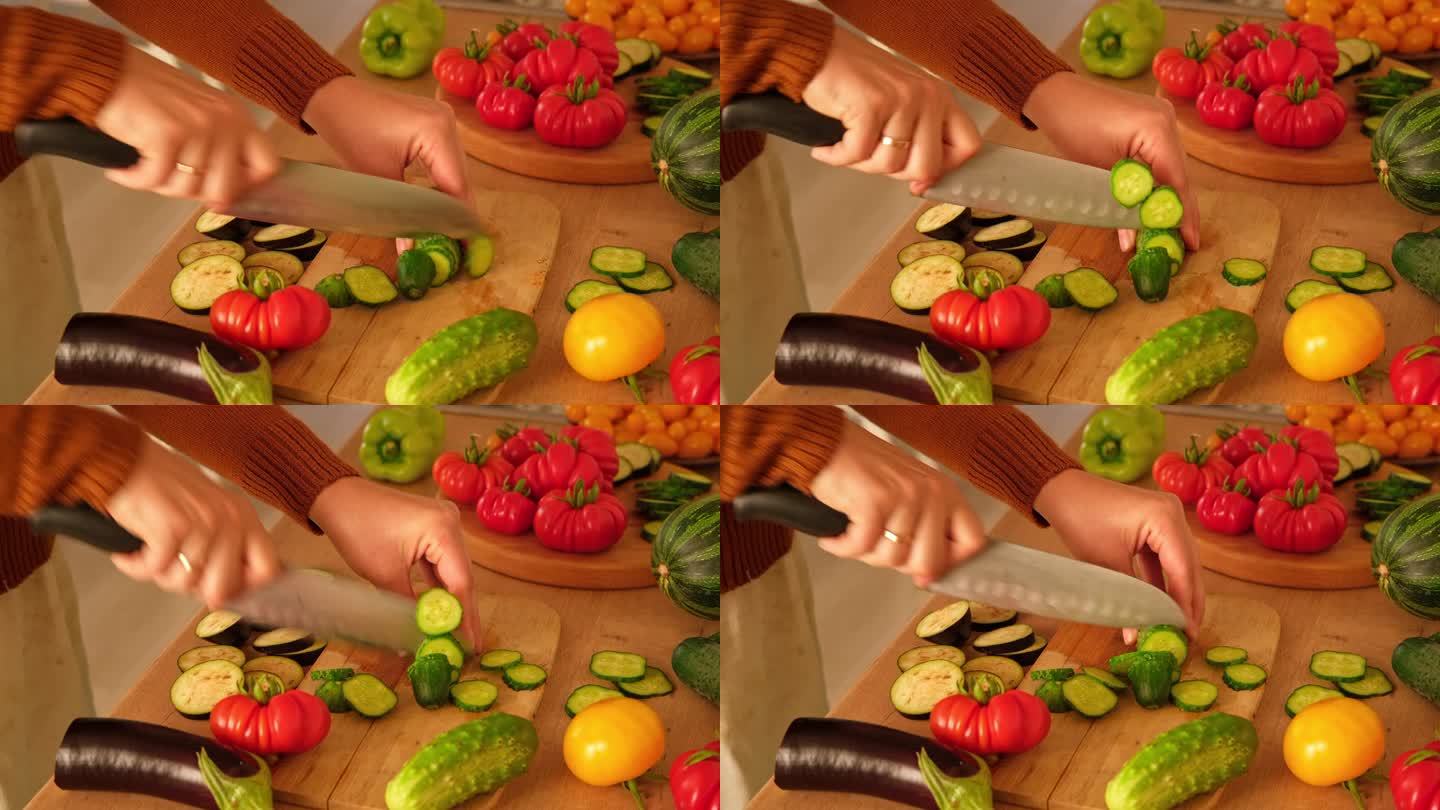 一个女人正在用刀切新鲜的生蔬菜。西红柿、黄瓜在木板上切成片。在家里做一顿健康的素食餐。准备素菜的切食