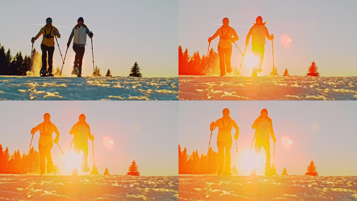 日落时分，两个徒步旅行者穿着雪鞋在雪地上奔跑