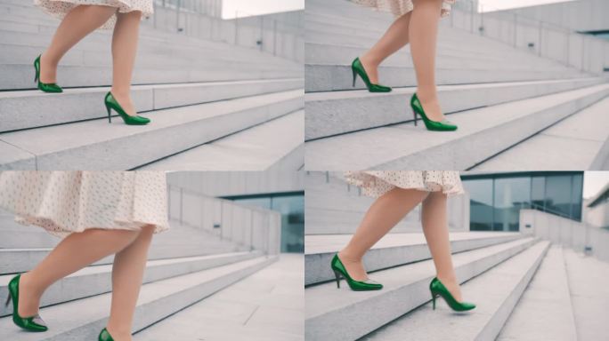 一个不知名的女人穿着裙子和绿色高跟鞋走下一座现代建筑前的楼梯