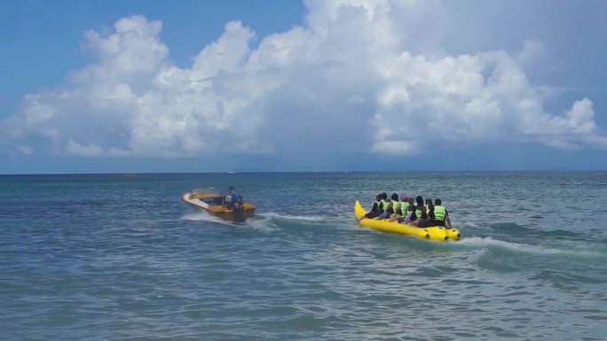 印度尼西亚肯达里——2022年5月4日:在Toronipa海滩上玩水，在海滩上乘坐香蕉船