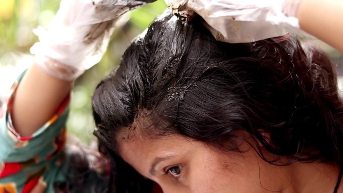女性在头发上涂抹曼海蒂(自然护发)