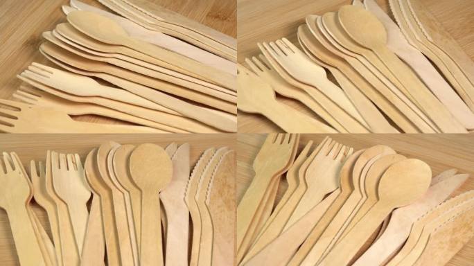 木制环保一次性餐具旋转。一排木勺、刀叉放在砧板上。厨房、餐厅一次性生态餐具