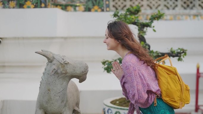 在笏阿伦寺，一名妇女向山羊雕塑致意