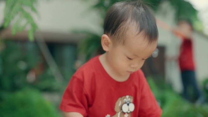 可爱的亚洲小男孩在户外泡泡游戏中快乐:天真的快乐和微笑的笑声