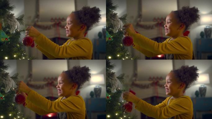 兴奋的女孩在家里把圣诞装饰品挂在树上