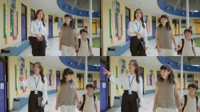 图为，学龄前儿童与老师、妈妈一起走过学校走廊。老师指着他旁边的现代化教室。
