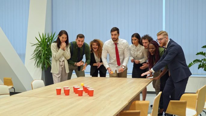 一群同事在办公室里玩啤酒乒乓球