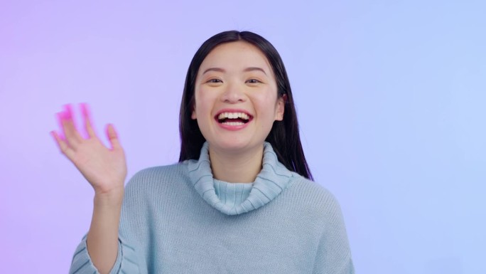 视频通话，一名亚洲女子的肖像在工作室背景下挥手表示欢迎。交流或你好联系，问候或介绍与女性的表情符号符