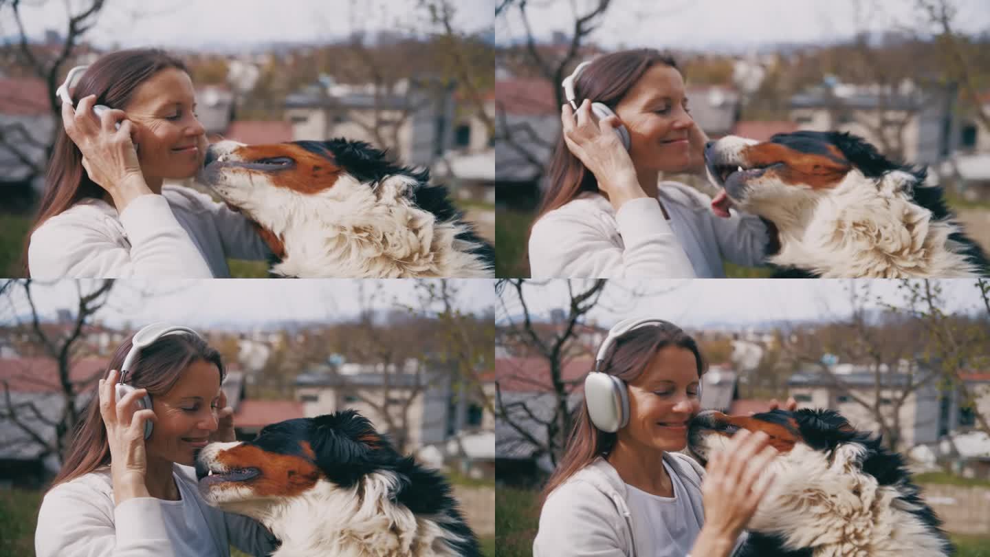在阳光明媚的城市公园里，快乐的女人带着耳机和狗