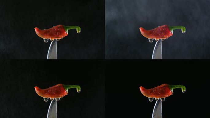 慢镜头:红辣椒刀尖在水喷雾。自然的烹饪