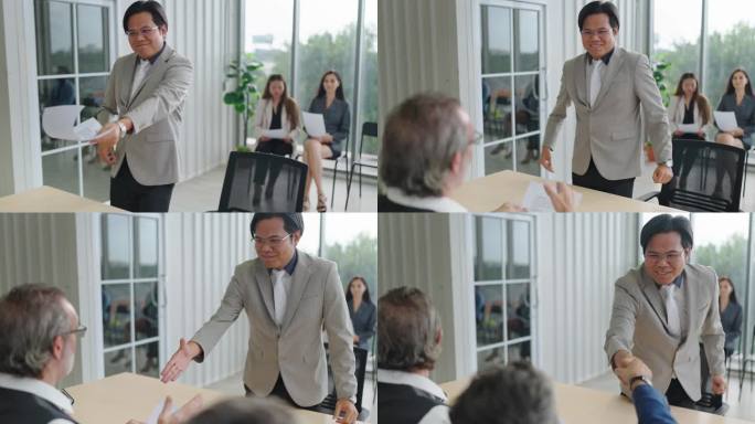 在会议室里，一名亚裔求职者在递简历时与招聘人员握手。求职面试与就业观念