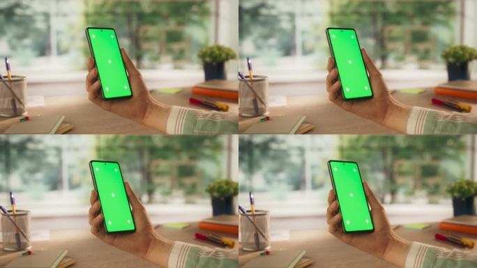 一个普通的人拿着智能手机，看着绿色的Chromakey模拟显示屏。视频模板与数字营销，创意应用程序演