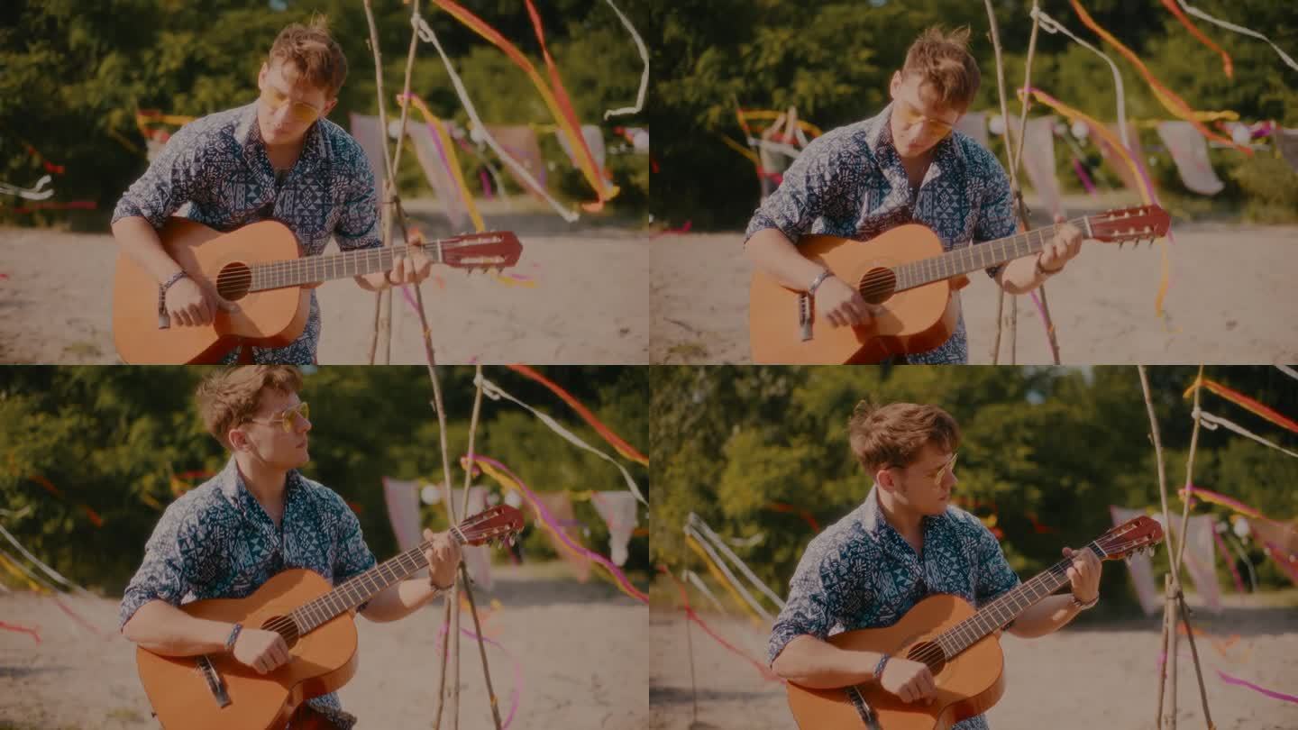 帅气的年轻人在沙滩上弹吉他。