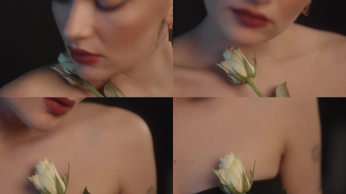 美丽的感性的女人与红色的口红黑色的背景工作室拍摄的姿势与单一的白玫瑰花