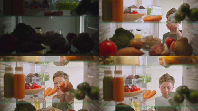 小男孩打开冰箱，从架子上拿了一根胡萝卜