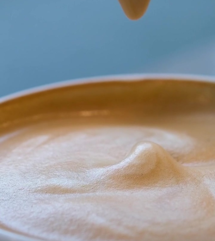一大杯加奶泡的卡布奇诺，早上在头顶上喝一杯心形拿铁咖啡，旧木背景上放着咖啡豆