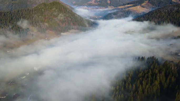 飞过山顶的云层。山峰高耸，清晨日出，自然景观优美