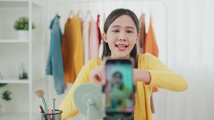 一名亚洲年轻成年女性正在网上直播化妆品评论，并向她的粉丝们提供化妆概念方面的建议。