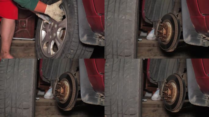 这个人拧下了汽车上的轮子，把它从车库里的汽车里取出来。一个男人自己在他的车库里给他的车换刹车盘。更换