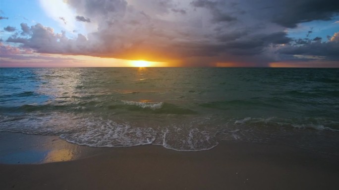 海洋景观与雷暴云在柔和的傍晚海水海浪粉碎沙滩。日落时美丽的海景