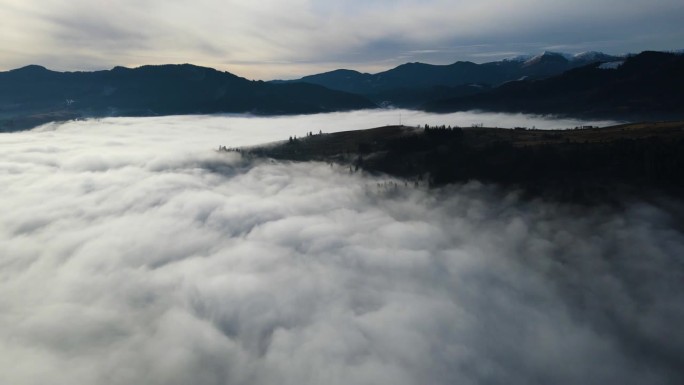 飞过山顶的云层。山峰高耸，清晨日出，自然景观优美