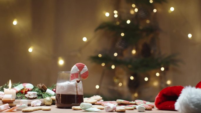 一个舒适的圣诞家庭内部设有一个桌子装饰着蜡烛，糖果，和一杯热巧克力。在背景中，灯笼和圣诞饰品增添了节