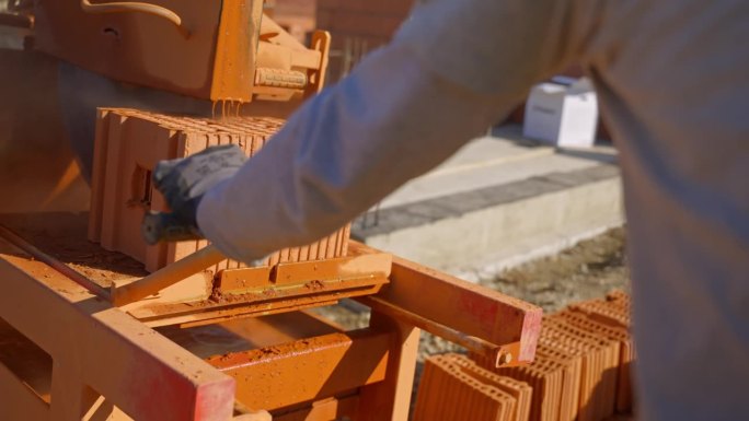 工地工人熟练地使用机器精确切割空心砖