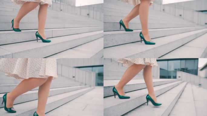 一个无法辨认的女人穿着祖母绿的高跟鞋走下一座现代建筑前的楼梯