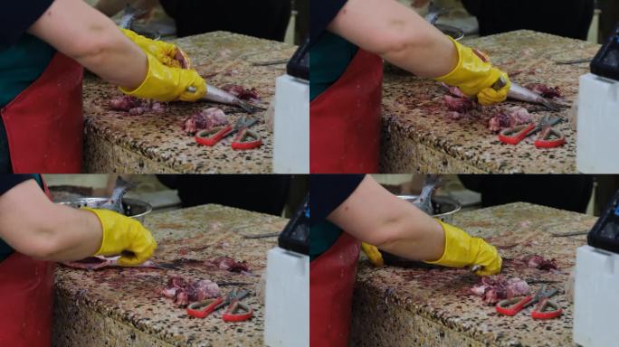 女鱼贩在市场上剥生鱼的内脏