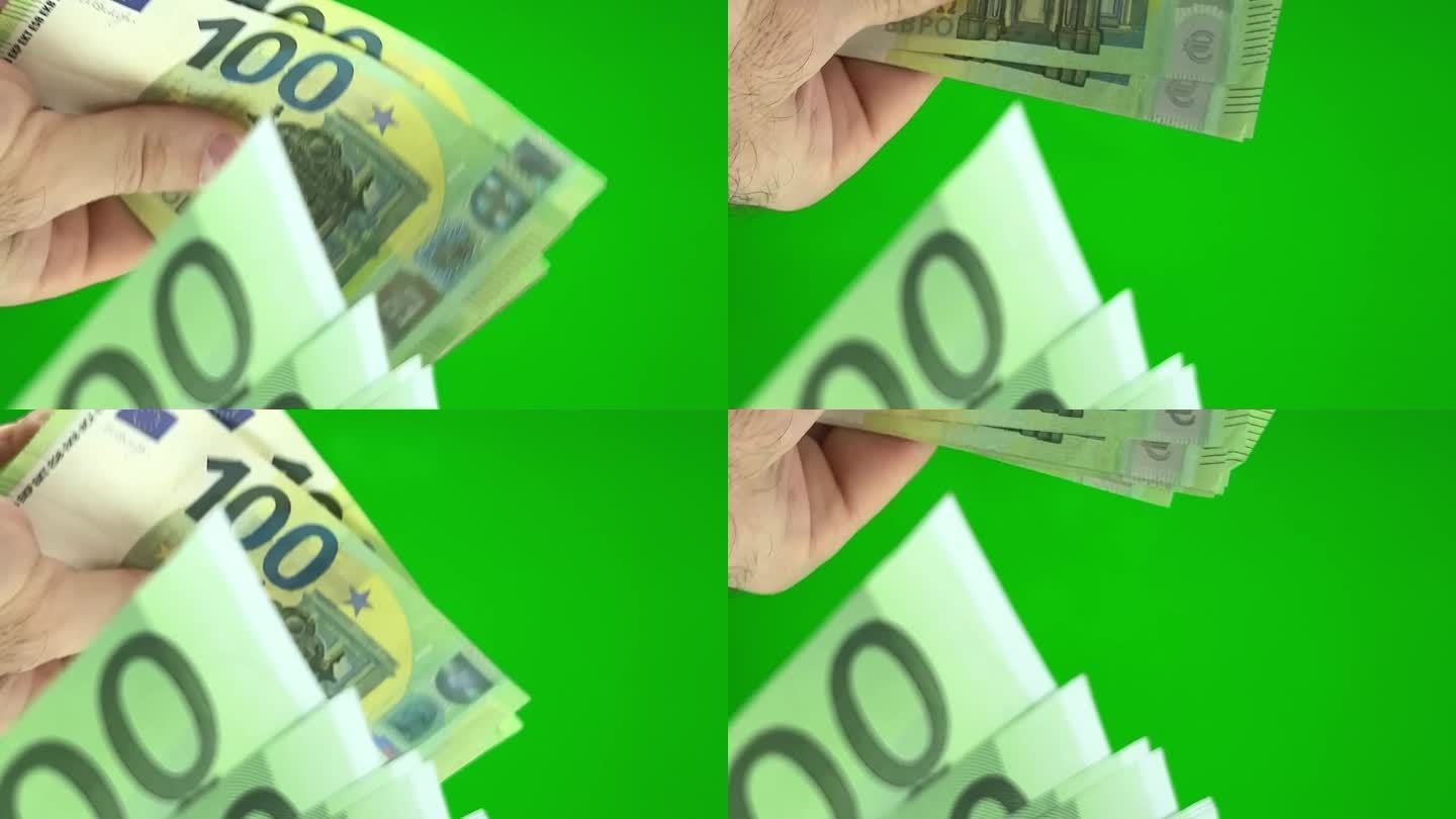 新旧钞票在手里呈扇形散开，一个女人手里有很多钱。欧元纸币和自动取款机在后台。钱在手。